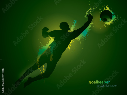 The football goalkeeper catches a ball on the dark background