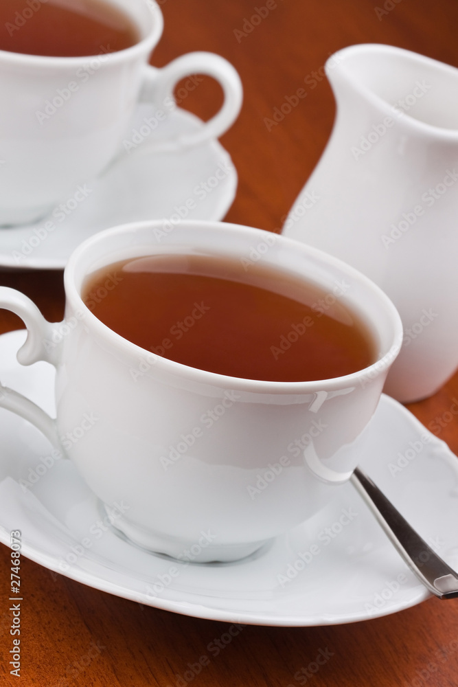 Black tea in mugs with saucers Black tea in mugs with saucers
