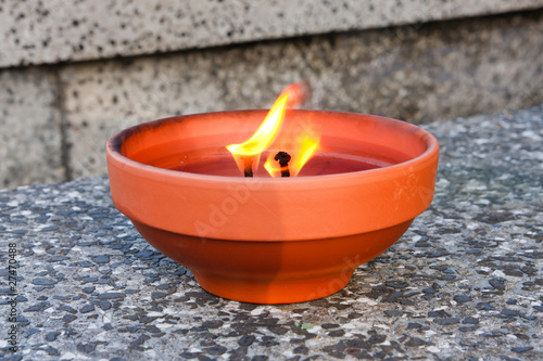 Burning candle standing on a grave