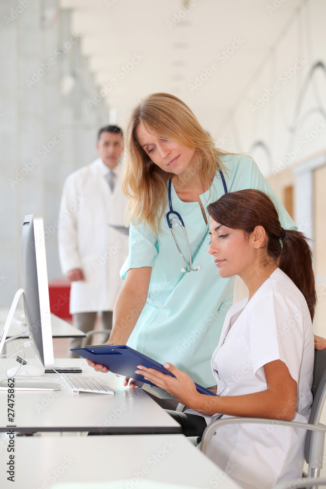 Nurse with intern working in front of computer Nurse with intern working in front of computer
