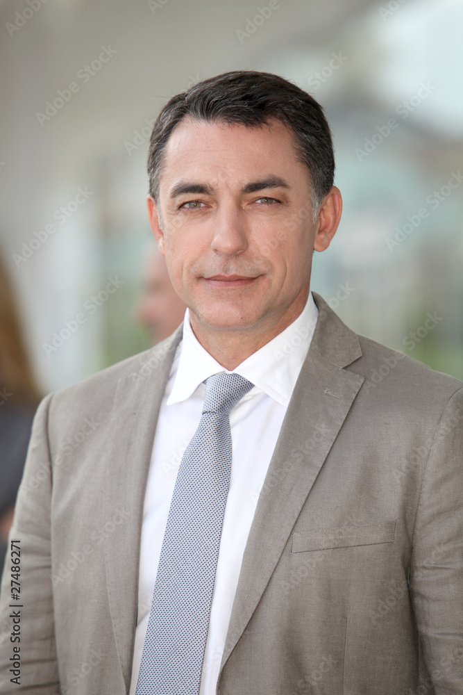Businessman standing outside modern building Businessman standing outside modern building