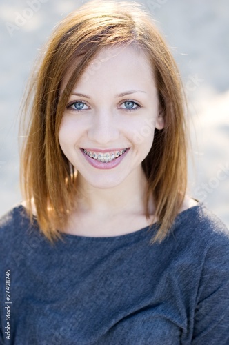 Charming teenage girl wearing braces and smiling cheerfully