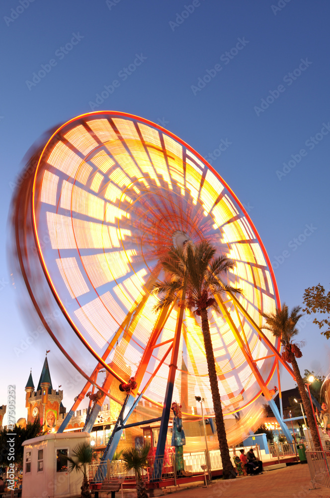 Motion blurred Ferris Wheel at night.
