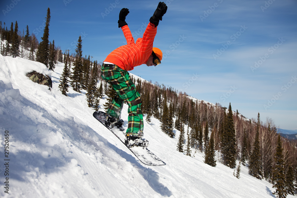Snowboarder jumping through air with  blue sky in background