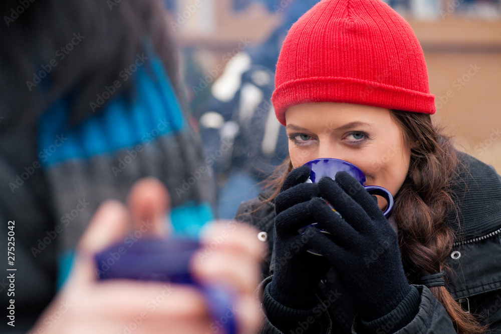 Fototapeta premium Frauen auf Weihnachtsmarkt trinken Glühwein