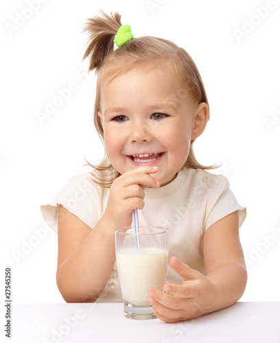 Little girl drinks milk using drinking straw