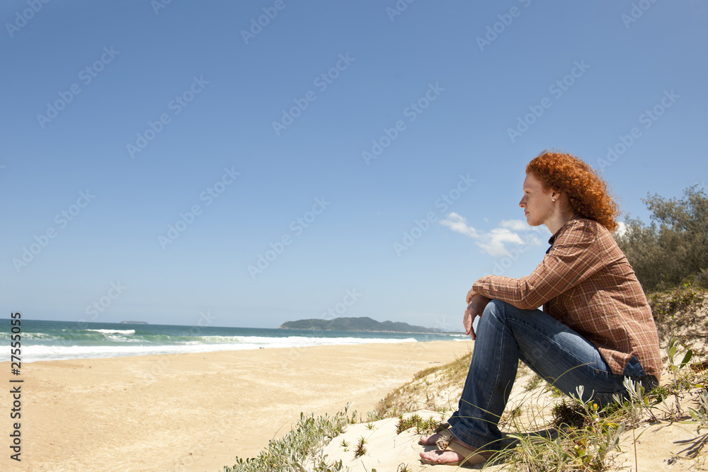 pensive woman sitting on the dunes