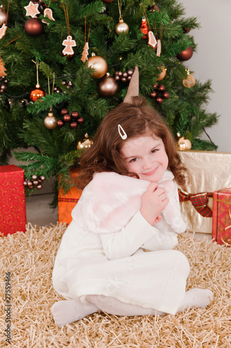 Little girl smiling in a front of Christmas-tree