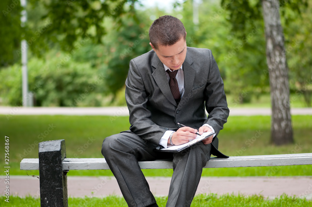 business man working with papers at park. Student business man working with papers at park. Student