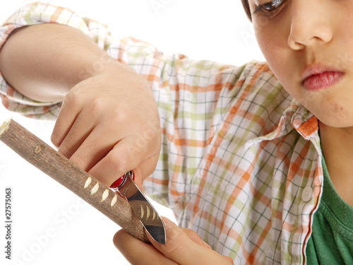 boy carving a tree branch isolated on white background photo