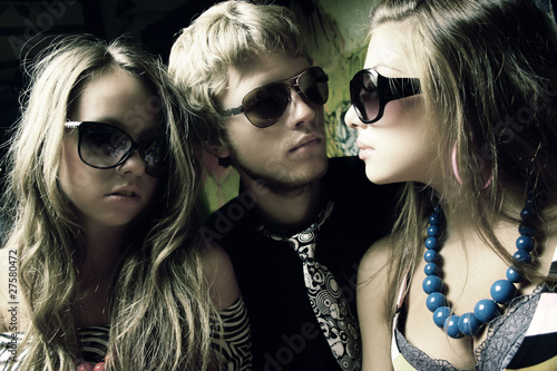 Fashion young guys and girls sitting together and having fun