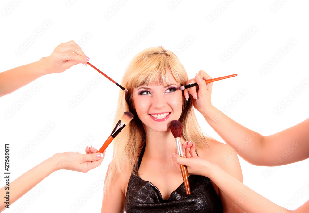 Obraz premium Beautiful young blonde woman with bright make-up and many brushe