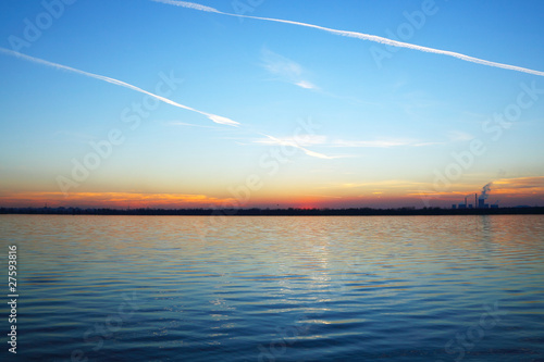 Sunset over the lake and a factory on the horizon