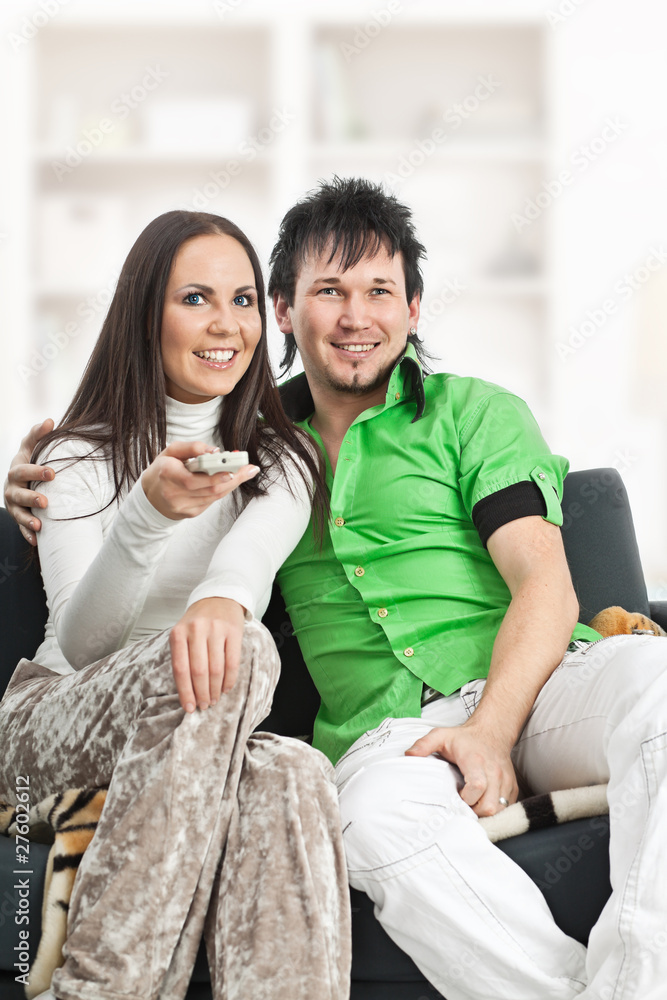 Smiling couple watches TV