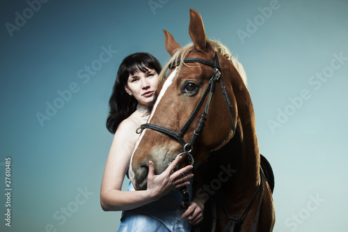 Beautiful young woman with a brown horse