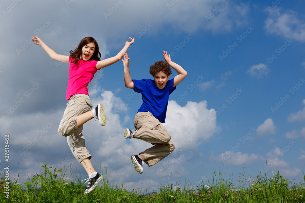 Girl and boy jumping, running against blue sky Girl and boy jumping, running against blue sky