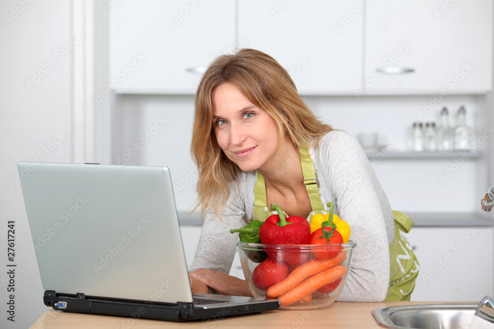 Woman in kitchen looking for cooking receipe Woman in kitchen looking for cooking receipe