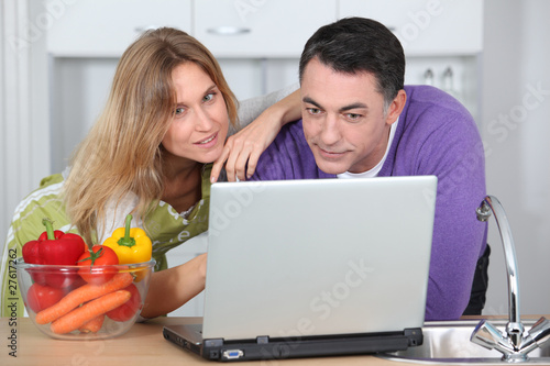 Canvas-taulu Couple in kitchen looking for cooking receipe