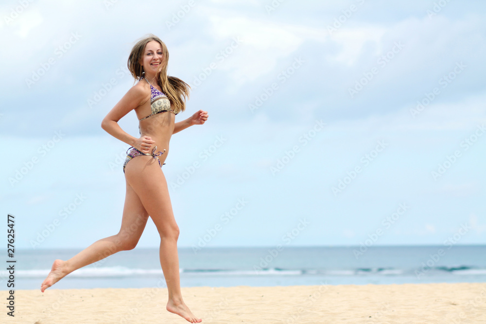 Fototapeta premium happy woman in bikini walks on a beach
