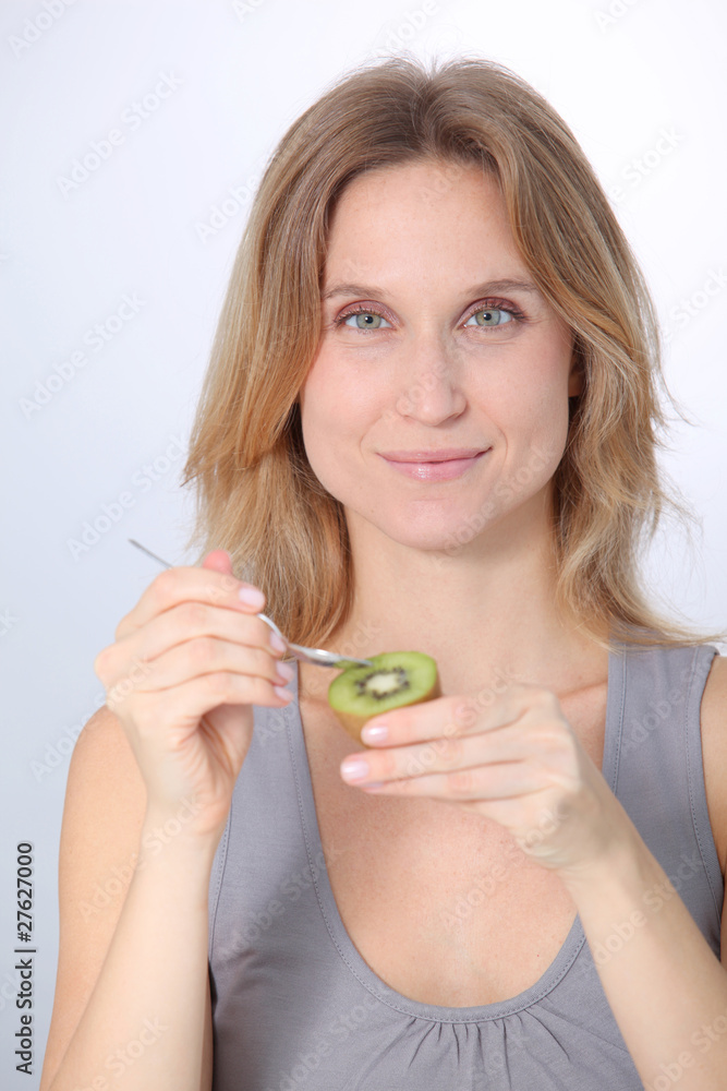 Beautiful blond woman eating kiwis Beautiful blond woman eating kiwis