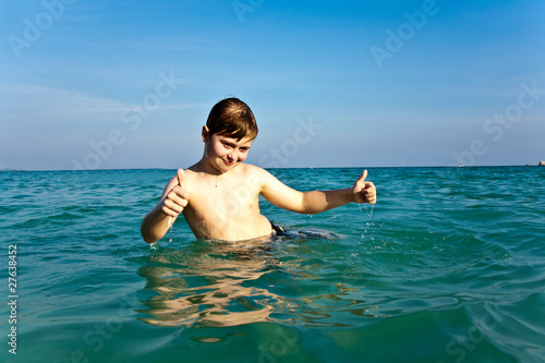 boy with red hair is enjoying the clear warm water photo