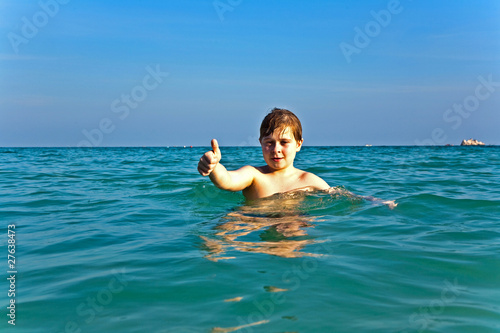 boy with red hair is enjoying the clear warm water