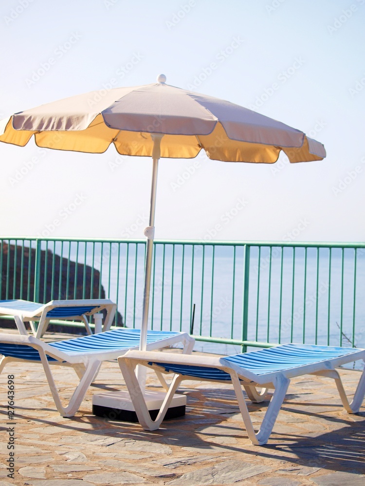 Sunbeds with parasol and view