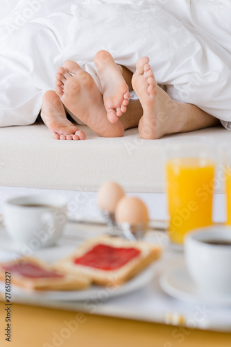 Luxury hotel honeymoon breakfast - couple in bed