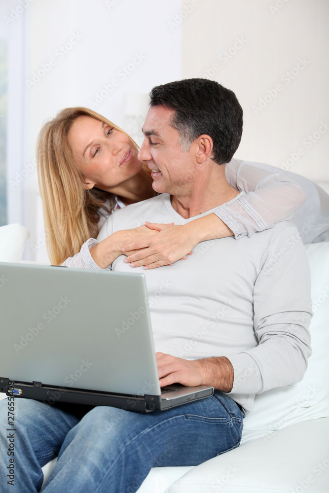 Happy couple surfing on internet at home