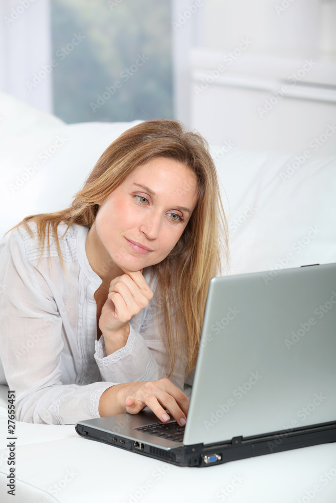 Beautiful blond woman surfing on internet at home Beautiful blond woman surfing on internet at home