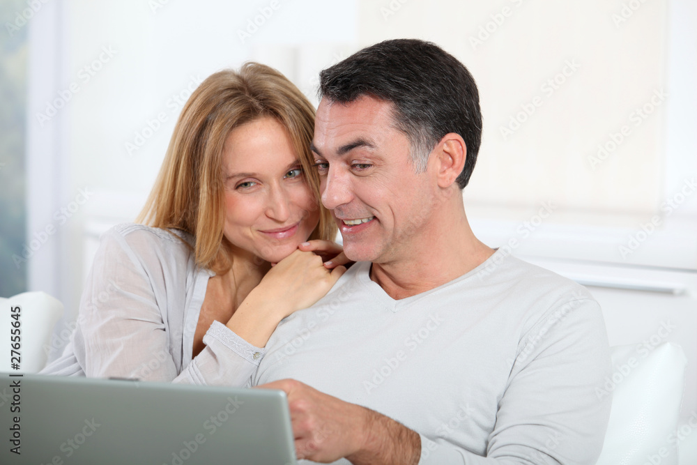 Happy couple surfing on internet at home Happy couple surfing on internet at home