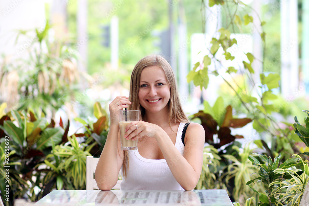 Young woman drinking coffee in a cafe outdoors Young woman drinking coffee in a cafe outdoors