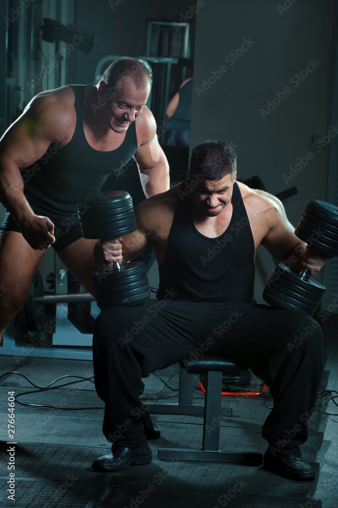 Obraz premium Two bodybuilders training in gym