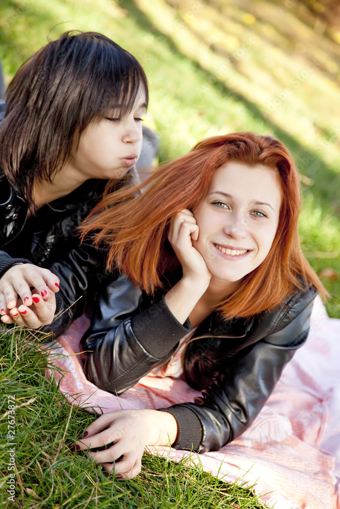 Fototapeta premium Two beautiful girlfriends at the autumn park near tree.