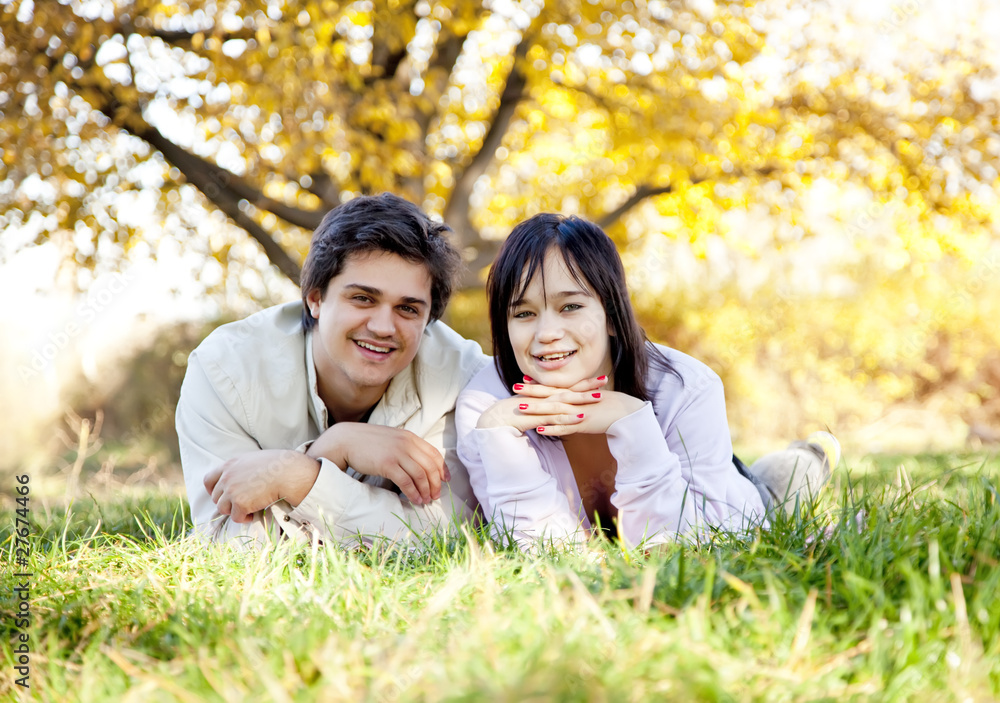 Couple lie at green grass in the park. Couple lie at green grass in the park.