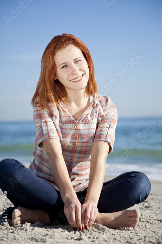 Happy red-haired girl at the beach.