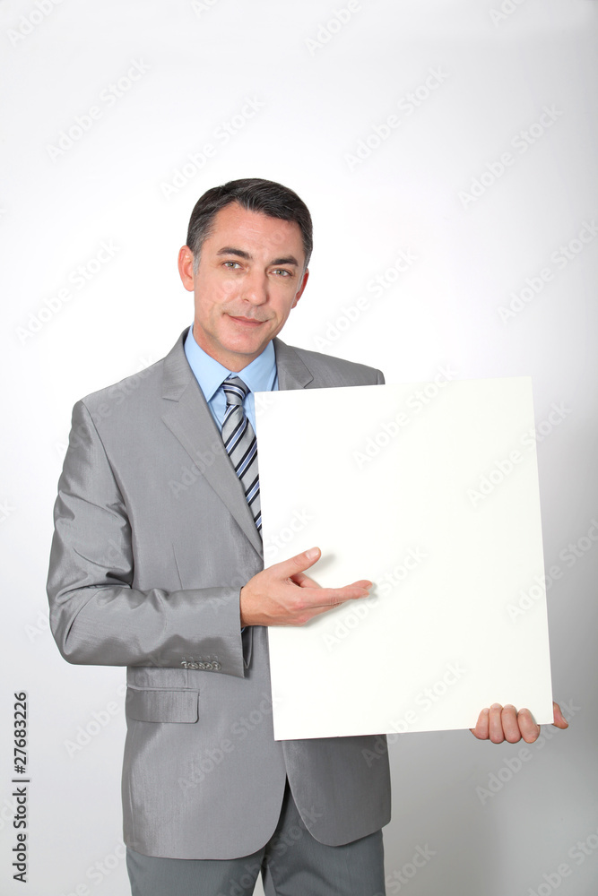 Businessman showing white message board Businessman showing white message board