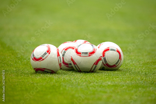 Mehrere Fussbälle liegen auf dem RasenFussballplatz photo