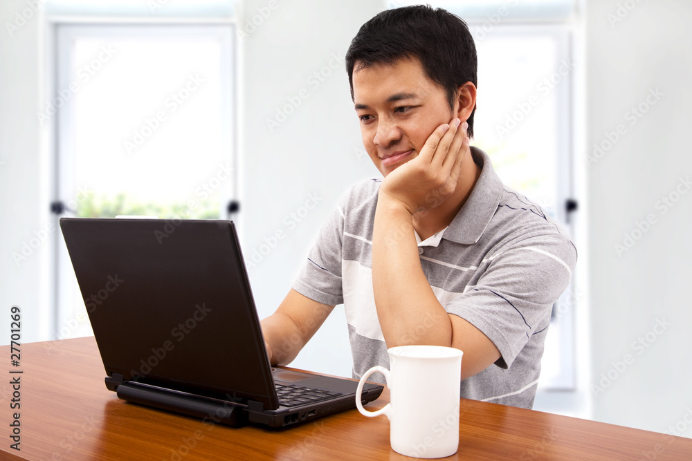 A happy young man using the laptop A happy young man using the laptop