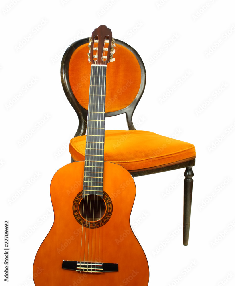 Akustische Gitarre vor antikem Stuhl mit Samt-Bezug