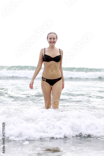 Young woman standing on a beach and enjoying the sun