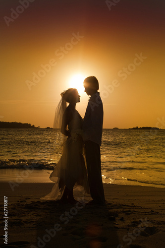 Bride and groom on beach.