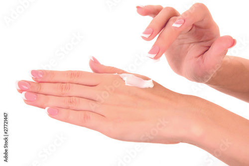 Closeup of beautiful female hands applying hand cream isolated o