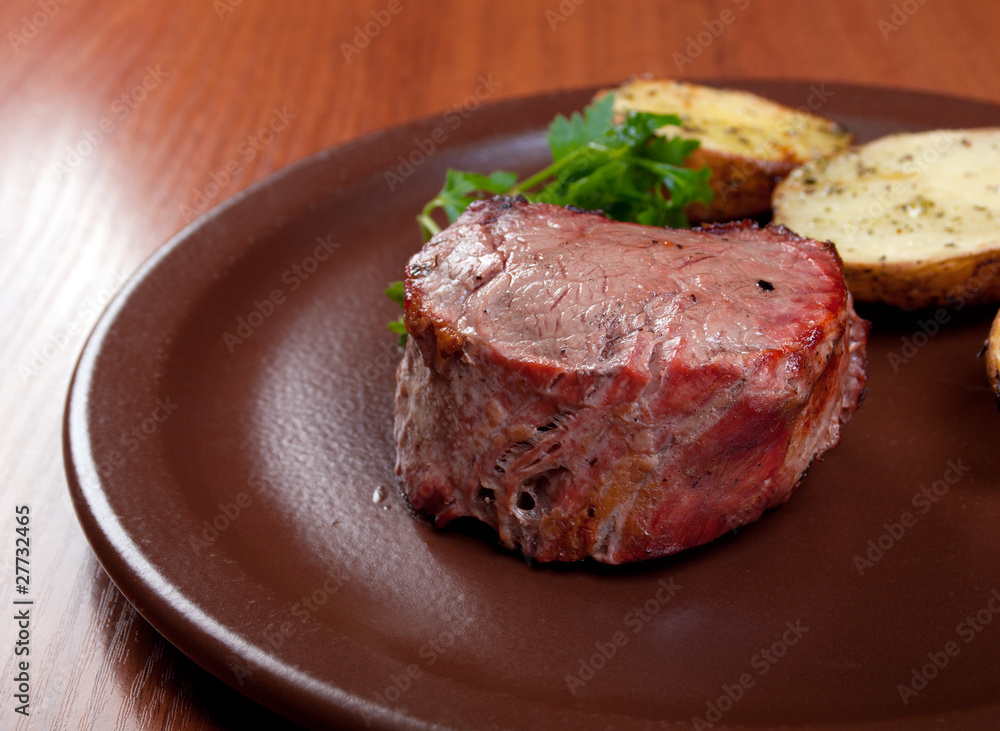 Grilled beef on white plate with potatoes Grilled beef on white plate with potatoes