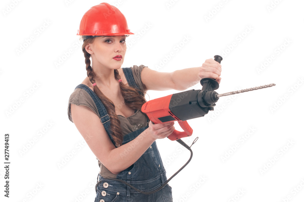 Young playful woman in jeans coverall holding perforator drill Young playful woman in jeans coverall holding perforator drill