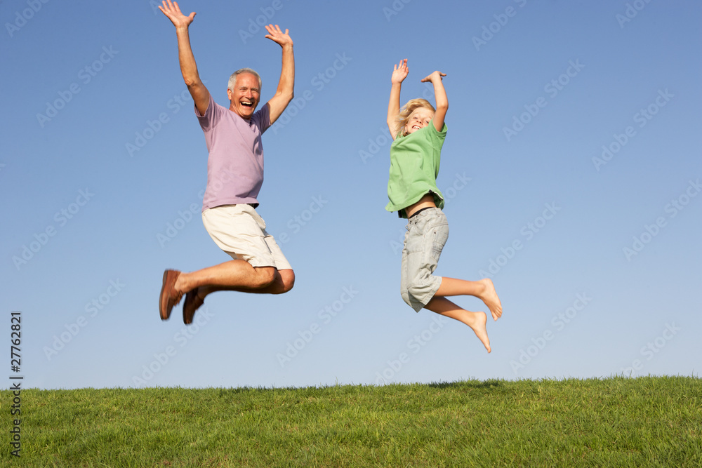 Senior man with grandson jumping in air Senior man with grandson jumping in air
