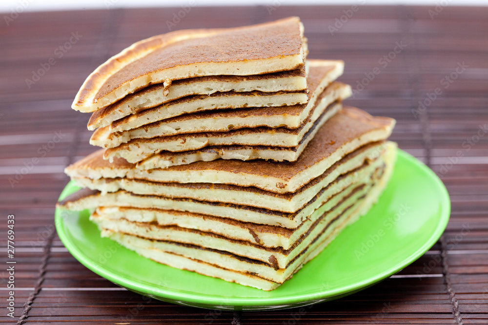 Pancakes on a plate on a bamboo mat Pancakes on a plate on a bamboo mat