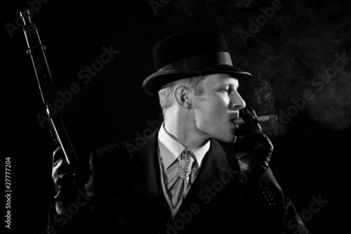 Man like a chicago gangster smokes a cigar
