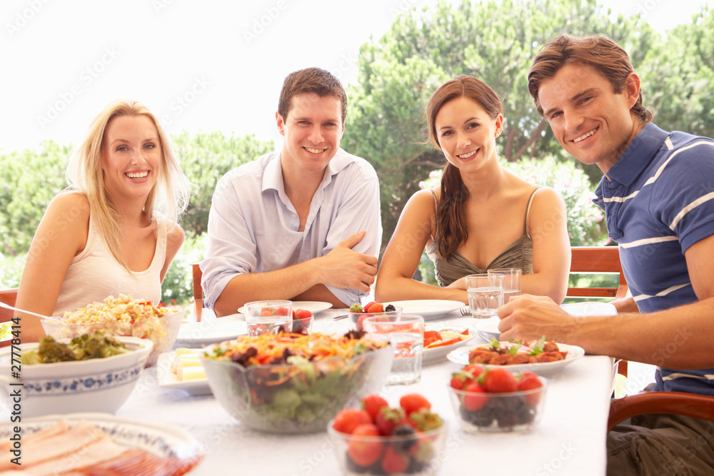Two young couples eating outdoors Two young couples eating outdoors