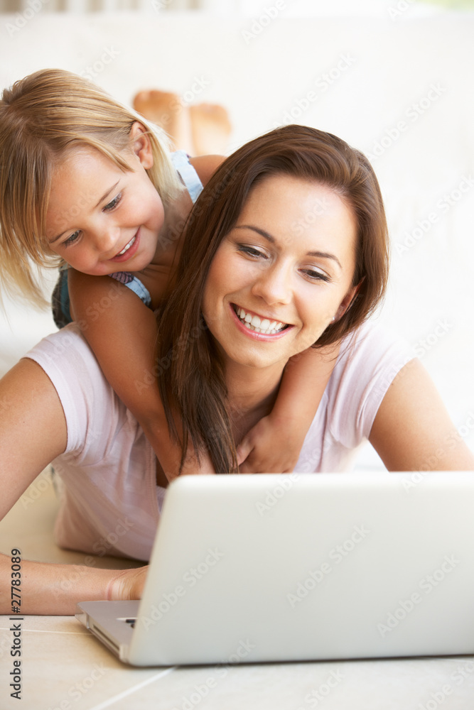 Young woman with girl using laptop computer